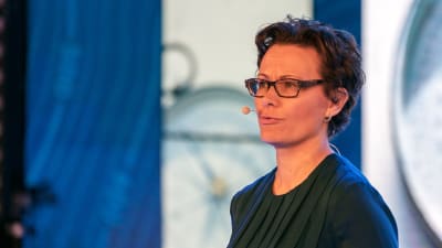 Kvinna talar på ett seminarium.