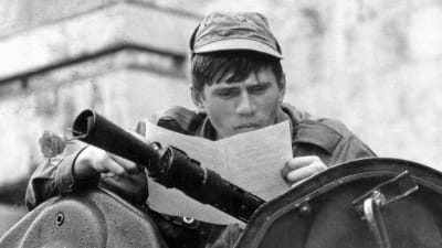 Soldaten på stridsvagn läser ett flygblad.
