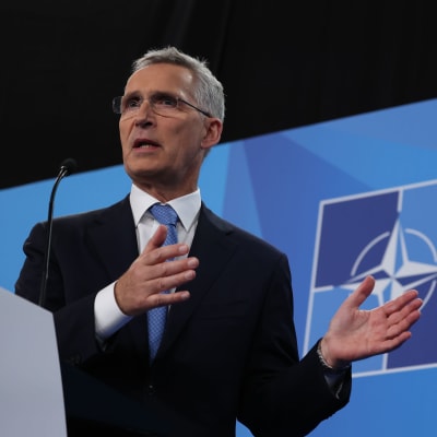 Naton pääsihteeri Jens Stoltenberg lehdistötilaisuudessa, taustalla Naton logo.