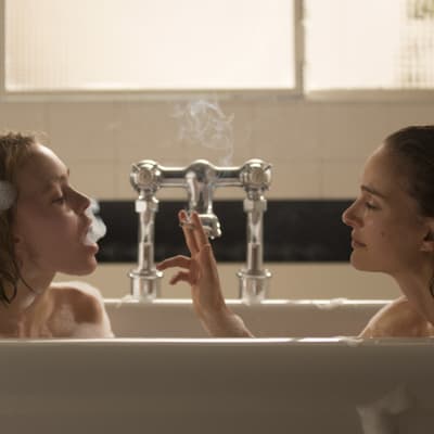 Kate (Lily-Rose Depp) och Laura (Natalie Portman) sitter i ett badkar och röker.