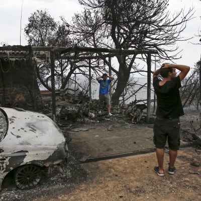 Invånare i Mati inspekterar sitt hus efter branden i Mati.