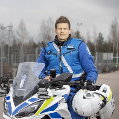 Vuoden poliisi 2021 Teppo Rainio istuu poliisimoottoripyörän kyydissä ja hymyilee.