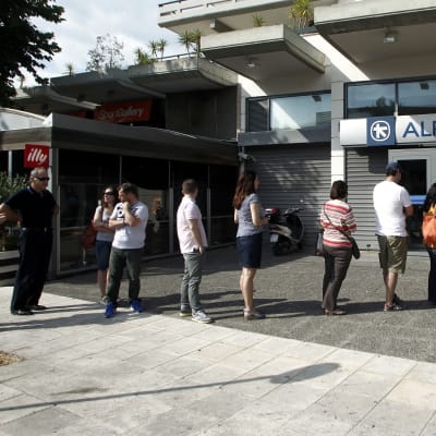 Greker köar vid bankautomaterna den 27 juni 2015.