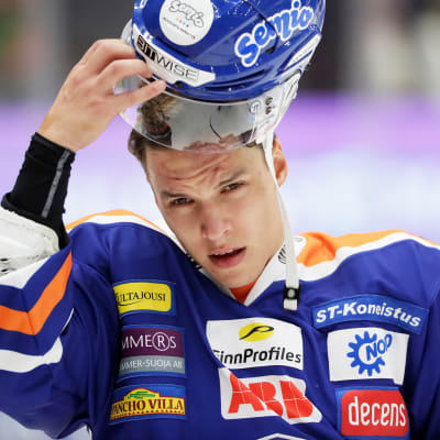 Tappara-pelaaja Jere Karjalainen laittamassa kypärää päähänsä.