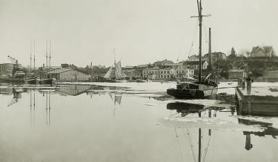 Ett svartvitt fotografi på en hamn där det står olika fartyg.