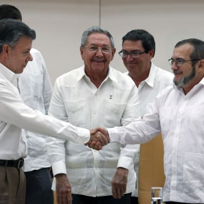Colombias president santos och Farc-ledaren Londono skkar hand efter i överenskommelse i Kuba.