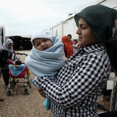 Syriska flyktingar i lägret Ritsona, norr om Aten. I förgrunden en kvinna som håller i ett spädbarn.