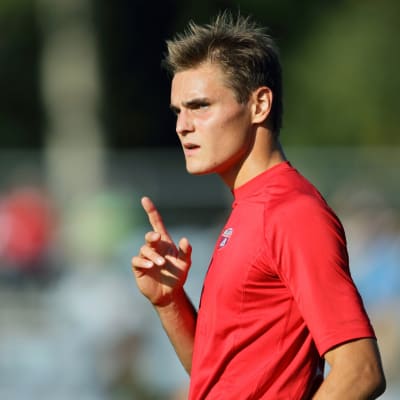 Rödklädda fotbollspelaren Sakari Tukiainen i solsken.