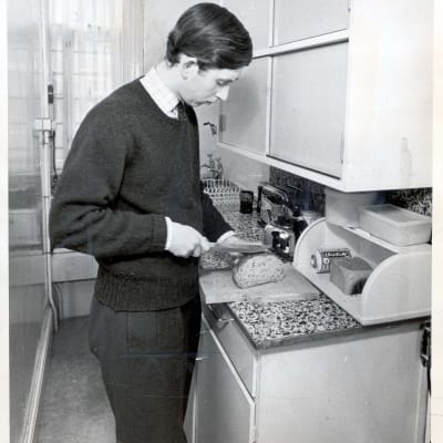 Prins Charles skär upp bröd i sin bostad på Trinity College, Cambridge 1969.