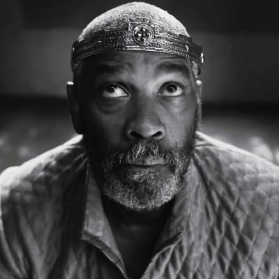 Denzel Washington roolissa Macbeth; viitta ja kruunu päässä lähikuvassa.