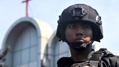 En indonesisk polis utanför en av de kyrkor i Surabaya som utsattes för attentat på söndagen. 
