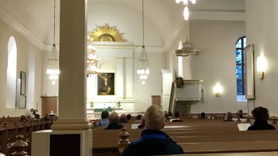 Fåtal kyrkobesökare i Kuopio domkyrka, bilden tagen inne i domkyrkan. 