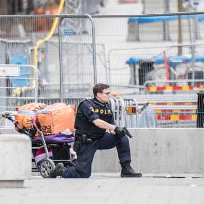 Polis med draget vapen i Stockholm.