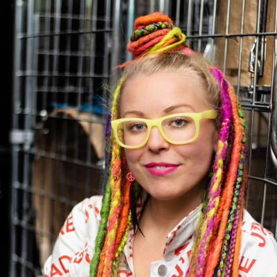 Vicky Österberg med färglada dreadlocks framför trummor.