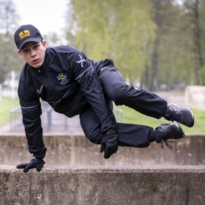 Upseerikokelas Jesper Linden hyppää yli betonisen esteen armeijan esteradalla.