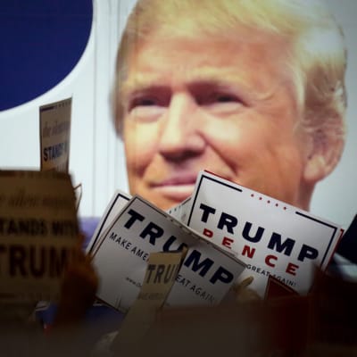 Donald Trumpia tukevia banderolleja Trumpin vaalijulisteen edessä.