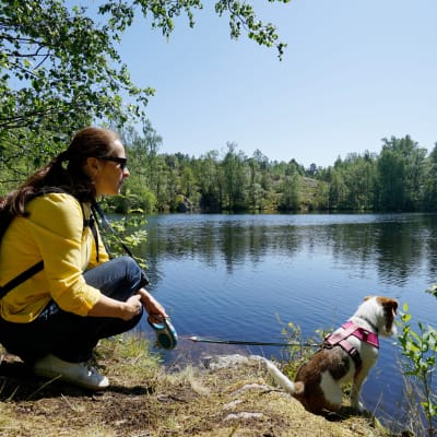nainen ja koira järven rannalla