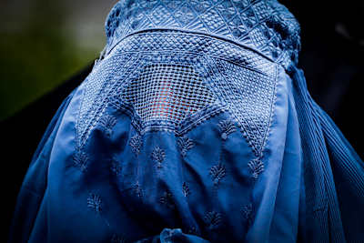 Närbild på en kvinna i blå burka. 