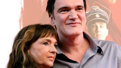 Christina Lindberg och Quentin Tarantino står bredvid varandra invid en filmplansch.
