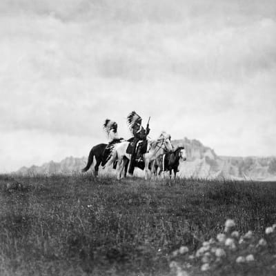 Kolme sioux-intiaania ratsailla.