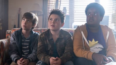 Trion i Good Boys sitter på en soffa och blickar uppåt.