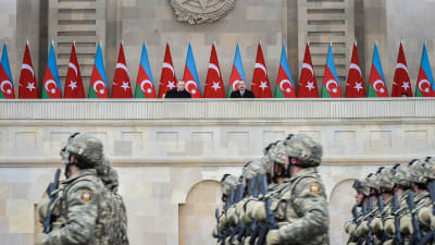 Soldater marscherar under en parad. I bakgrunden står Turkiets och Azerbajdzjans presidenter