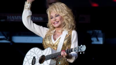 Dolly Parton med gitarr på konsertestraden.