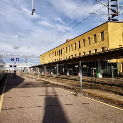 InterCity-juna asemalaiturilla, vieressä työmaaiadan takana poistettuja raiteita Turun päärautatieaseman edustalla.