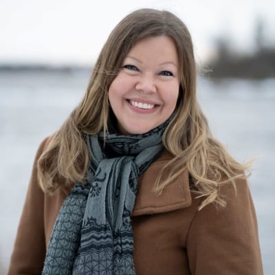 Leende kvinna i vinterlandskap.