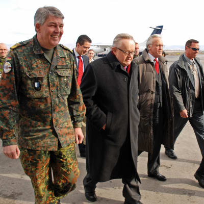 Roland Kather , Martti Ahtisaari ja Joachim Råcker kävelevät lentokentällä.