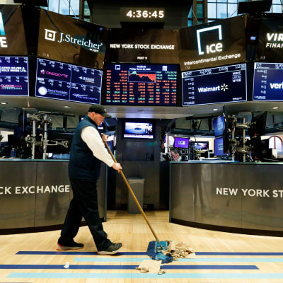 Mies lakaisee lattiaa New Yorkin pörssissä.