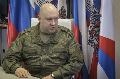 Den ryska generalen Sergej Surovikin sitter framför en rad ryska flaggor.