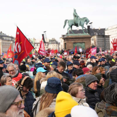 Mielenosoittajia kylttejä ja lippuja käsissään Kööpenhaminassa.