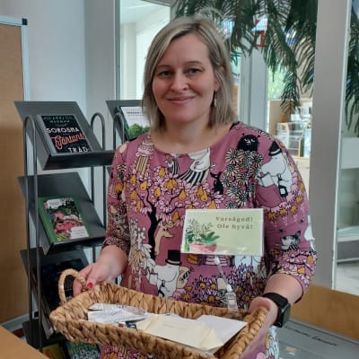 Korsholms bibliotekschef Maria Kronqvist-Berg visar upp en korg med fröpåsar ur fröbiblioteket