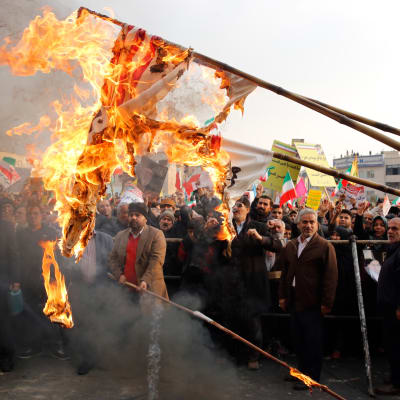 Hallintoa tukeva mielenosoitus Teheranissa Iranissa 25.11.2019. Mielenosoittajat polttivat Yhdysvaltain lippuja.
