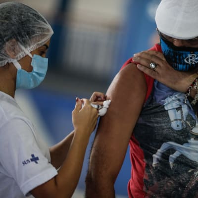 En man får en dos av Astra Zenecas coronavaccin i Brasilien