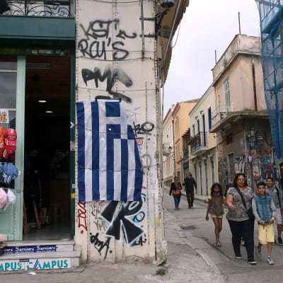 En grekisk flagga hänger utanför en butik i stadsdelen Plaka i Aten.
