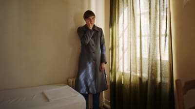 kvinna stående med ytterkläder i ett rum i Frankrike