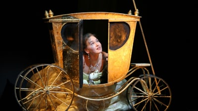 Jenny Carlstedt som Askungen i Rossinis opera La Cenerentola kikar ut från en hästvagn.