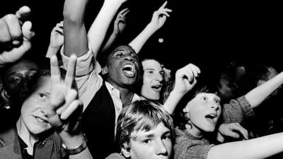 Rock-konsertin yleisöä lähikuvassa. 1978 Lontoo, kuva dokumenttielokuvasta White Riot.