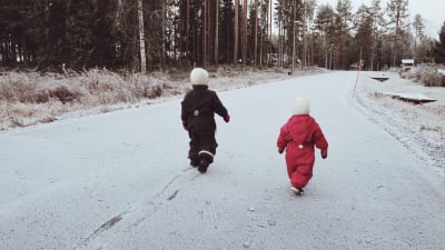 Barn som går på en snöig väg.