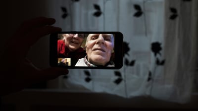 Ett äldre par i mobilen under ett videosamtal. 