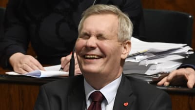 Antti Rinne skrattar gott i plenisalen i riksdagen den 8.3.2019.