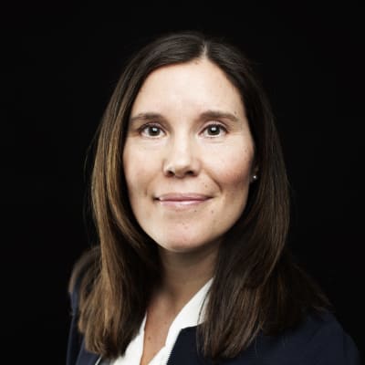 En mörkhårig leende kvinna.