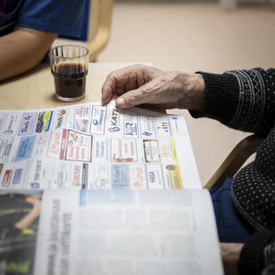 En äldre person läser en tidning
