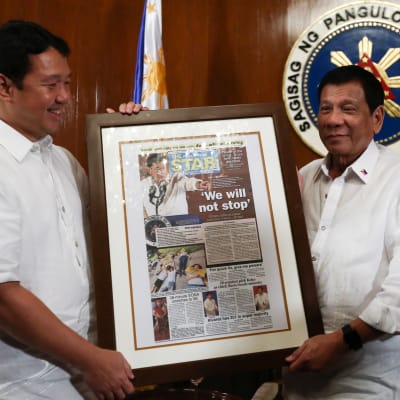 President Rodrigo Duterte (tv) emottar en dagstidnings förstasida där det står, Vi kommer inte att stoppa - en hänvvisning till Duertes omstridda kampanj Skjut för att döda