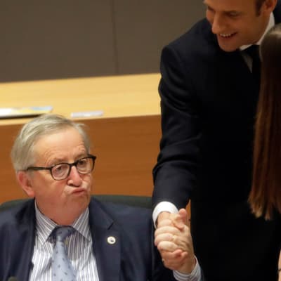 Macron puristaa Junckeria kädestä