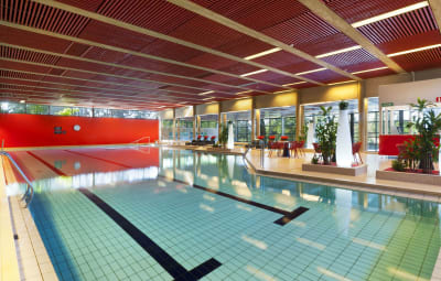 En simbassäng i Sjundeå bad, med växter och fönster i bakgrunden.