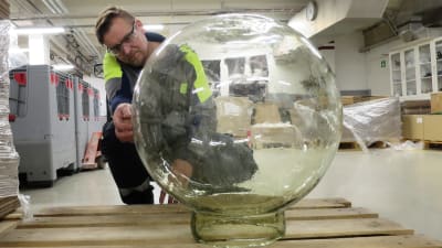 En man undersöker en enorm glaskupa. 
