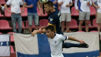Simon Skrabb i en nickduell med en spelare från Bosnien